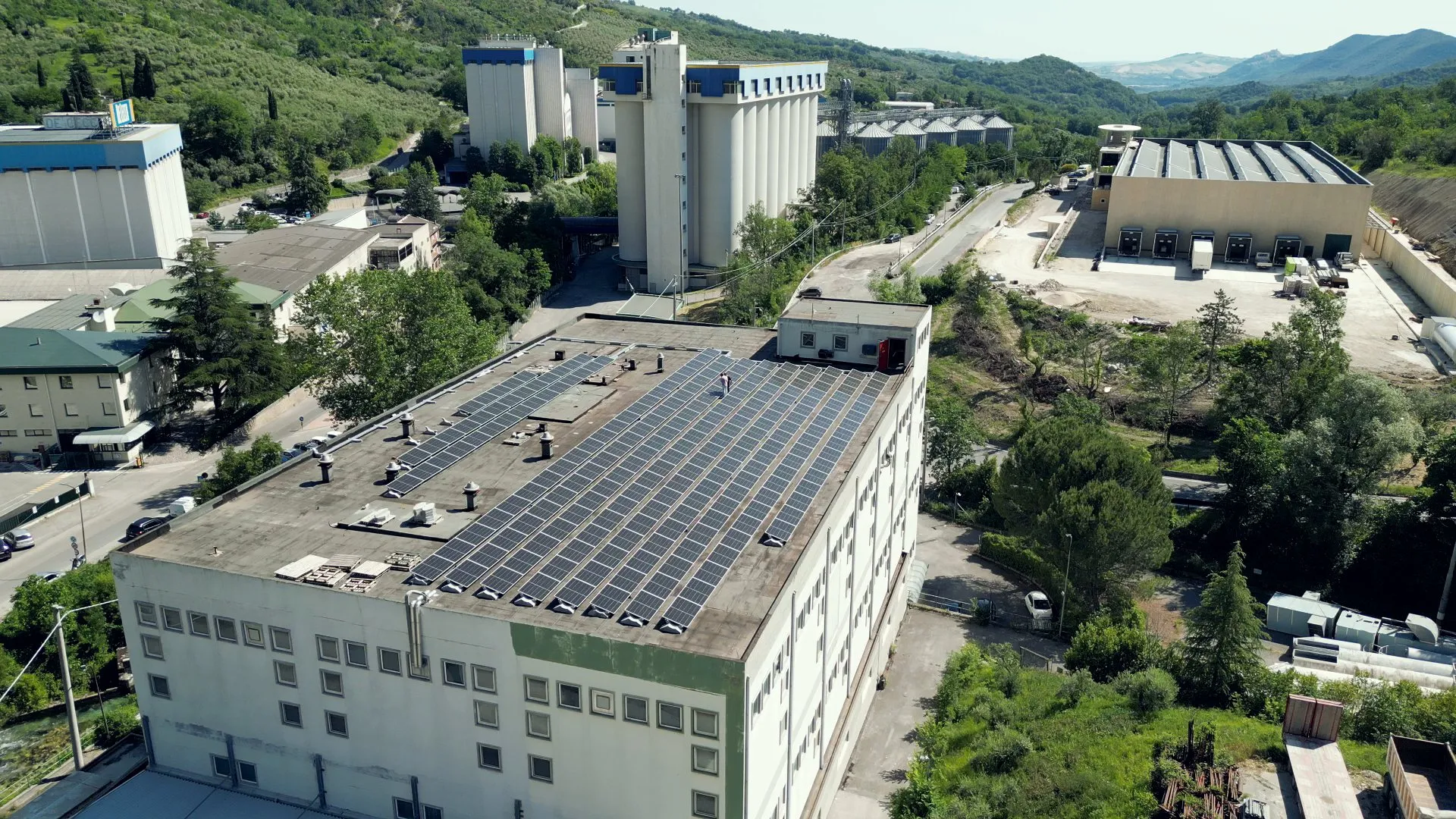Rooftop solar system on an industrial building installed by New Energy, drone view